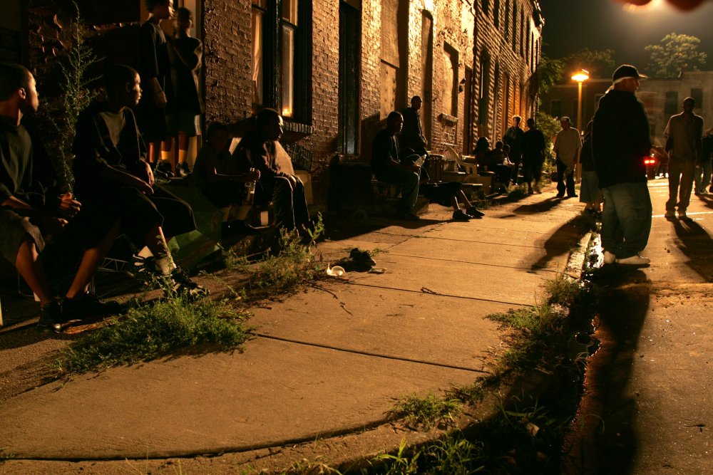 wire-the-2000s-001-people-standing-outside-houses-down-dark-tenement-street.jpg