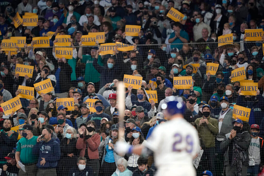 Fans hold Believe signs as Seattle Mariners' Cal Raleigh bats against the Los Angeles Angels during the second inning of a baseball game, Sunday, Oct. 3, 2021, in Seattle. Raleigh grounded out on the play. (AP Photo/Ted S. Warren)