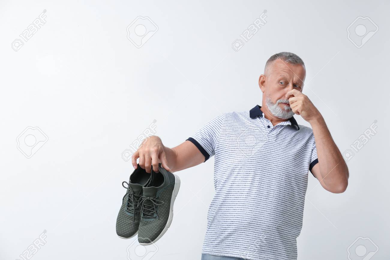 107795839-man-feeling-bad-smell-from-shoes-on-white-background-air-freshener.jpg