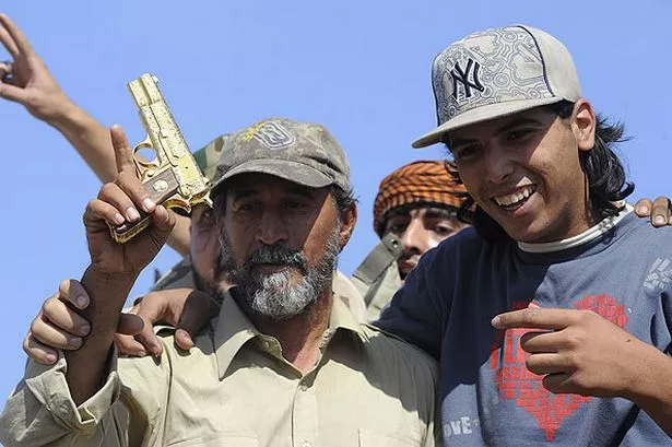 a-man-holds-up-colonel-gaddafi-golden-gun-pic-getty-images-181267303.jpg
